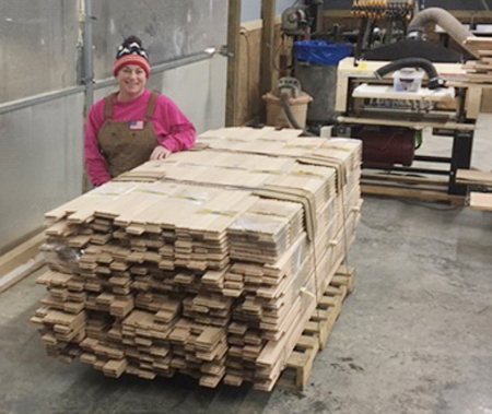 Amy and Robert work side-by-side. Here's Amy with a big load of hardwood flooring they shipped out recently. Note the Woodmaster in the background.