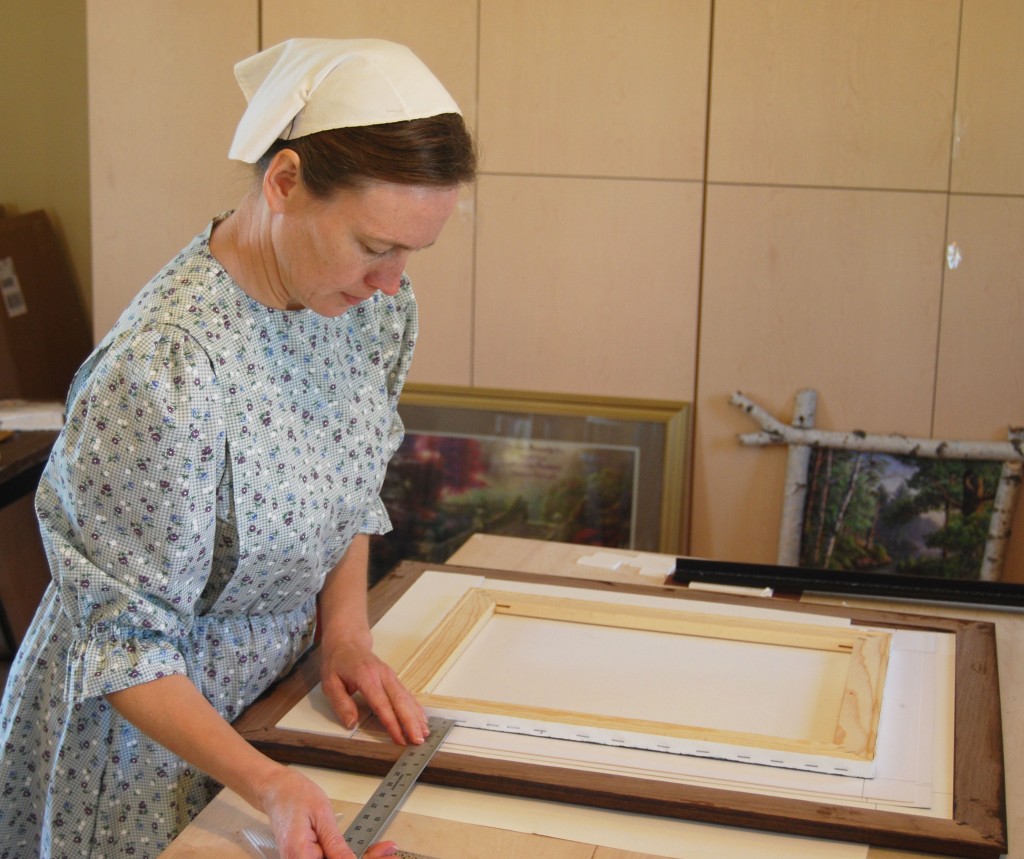 The whole Bardwell family is involved in their framing business. Karla's doing framing in Frameworxz's Studio.
