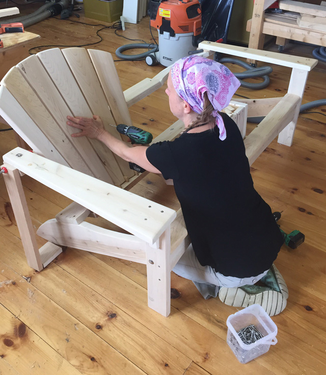 Rob's business started to take off to the point that he needed another pair of hands. Along came Melissa, shown here putting finishing touches on one of their handsome white cedar Adirondack chairs.